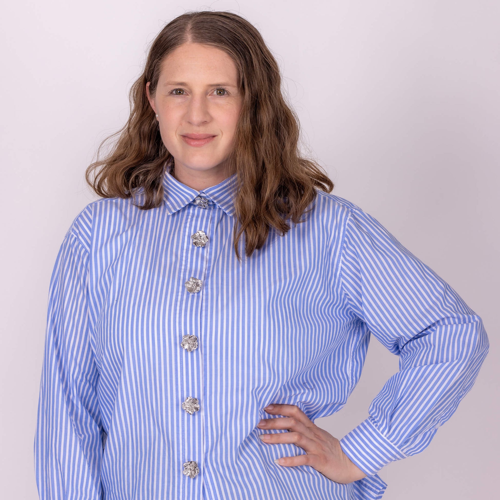 woman wearing shirt with silver flower button covers